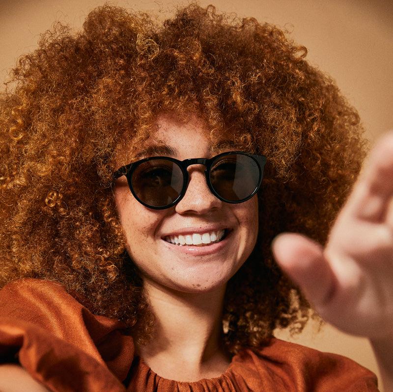 Female model wearing black polarised sunglasses